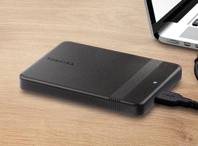 Toshiba Canvio Ready taşınabilir sabit disk, yuvarlatılmış köşelere ve tutuş için dar bir şeride sahip siyah renkli bir kasaya sahiptir.