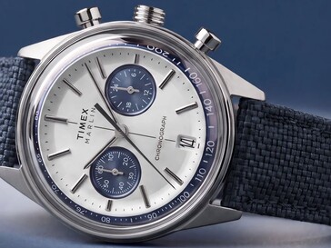 Koyu bir arka plan önünde fotoğraflanan Timex Marlin Jet Chronograph, bombeli camını, takimetre çerçevelerini, içbükey kadranını, kronograf alt kadranlarını ve retro-fütürist kasa tasarımını sergiliyor.