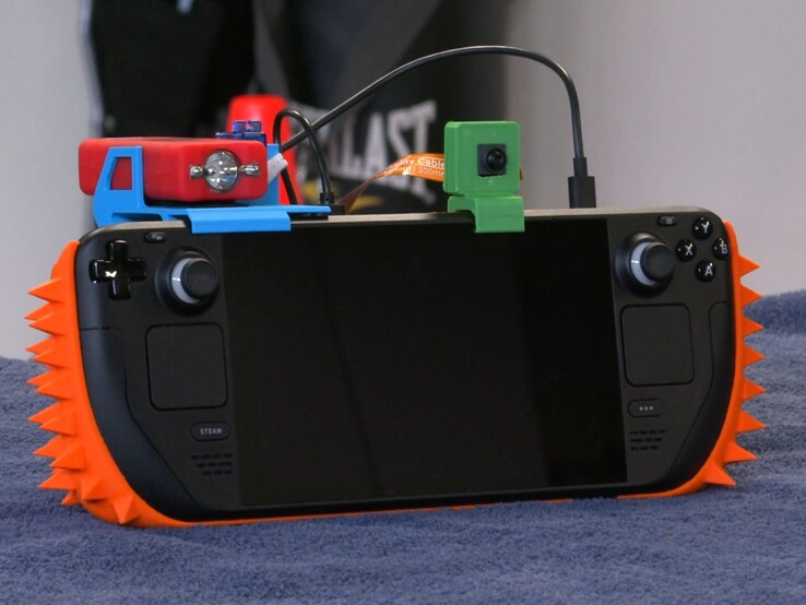 Çiviler, bir kamera ve bir şok tabancasından oluşan bir DIY güvenlik sistemi ile donatılmış bir Steam Deck.
