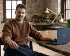 Henry Cavill, elinin altında bir Googlebook ile masada oturuyor.