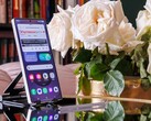 Bir masanın üzerinde dik duran bir Samsung Galaxy S25 Ultra, ekranda açık bir web sitesi görünüyor