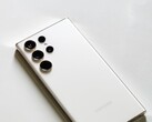Açık renkli bir yüzey üzerinde dört arka kameralı beyaz Samsung Galaxy akıllı telefon.