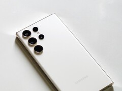 Açık renkli bir yüzey üzerinde dört arka kameralı beyaz Samsung Galaxy akıllı telefon.