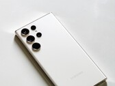 Açık renkli bir yüzey üzerinde dört arka kameralı beyaz Samsung Galaxy akıllı telefon.