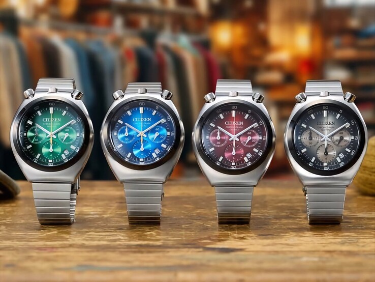 Ahşap bir yüzey üzerinde yan yana sergilenen, yeşil, mavi, kırmızı ve gri renk geçişli kadranlara sahip dört Citizen Tsuno Chronograph saat, paslanmaz çelik