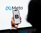Bir el, büyük bir Meta logosunun önünde bir akıllı telefon tutuyor
