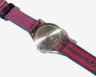 Noah x Timex MK1 Anchor saatinin arka görünümü; saatin üzerine oyulmuş paslanmaz çelik arka kapağı ve lacivert-kırmızı kumaş kayışı görülmektedir.