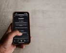 Gri taş bir yüzeyin üzerinde ChatGPT arayüzünü gösteren bir akıllı telefonu tutan el