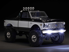 Axial SCX24 paletli aracın koyu bir arka plana karşı görüntüsü.