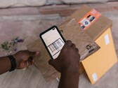 Bir el, bir paketin üzerinde tuttuğu akıllı telefonla barkodunu tarıyor.