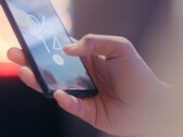 Bir el, bir akıllı telefonu tutuyor ve kilit ekranındaki parmak izi sensörünü kullanarak kilidi açıyor.