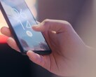 Bir el, bir akıllı telefonu tutuyor ve kilit ekranındaki parmak izi sensörünü kullanarak kilidi açıyor.