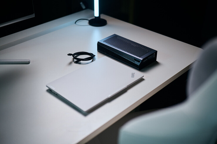 Masada, kompakt Aorus RTX 5060 Ti AI Box eGPU ve sarmal bir Thunderbolt kablosunun yanında duran, kapalı beyaz bir ThinkPad dizüstü bilgisayar.
