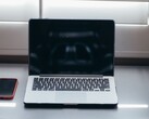 Gün ışığında bir masanın üzerinde dizüstü bilgisayarı ve akıllı telefonu yan yana açın