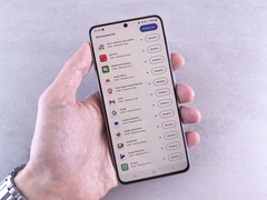 Bir el, ekranında güncelleme listesini gösteren bir akıllı telefonu tutuyor.