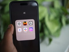 Ekranında yapay zekâ uygulamalarıyla dolu bir klasör bulunan bir akıllı telefonu tutan el