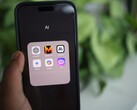 Ekranında yapay zekâ uygulamalarıyla dolu bir klasör bulunan bir akıllı telefonu tutan el