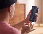 Gboard'da tanınan metni gösteren bir Pixel telefonun önünde tek eliyle işaret diliyle işaret eden kişi