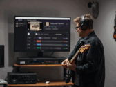 Gitarist, StemKit uygulamasını gösteren bir monitörün önünde çalıyor.