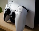 Bir PS5 konsoluna yaslanmış bir PlayStation 5 DualSense kontrol cihazının fotoğrafı