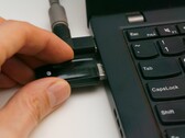 Bir kişi dizüstü bilgisayara bir USB güvenlik anahtarı takar
