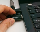 Bir kişi dizüstü bilgisayara bir USB güvenlik anahtarı takar