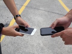 Teslim sırasında iki akıllı telefonu yan yana tutan iki kişi
