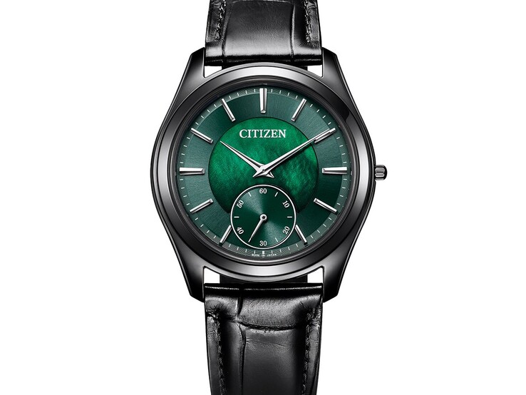 Citizen Eco-Drive One AQ5025-04N modelinin ışıltılı yeşil sedef kadranını, gümüş tonlu akrep, yelkovan ve indekslerini, siyah kasasını ve deri kayışını gösteren açılı yakın plan görüntüsü.