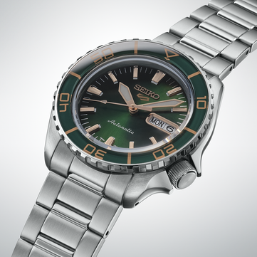 Close-up of the Seiko 5 Sports SKX HDB005, highlighting its dark green dial, rose gold-colored hands and applied indexes, and matching green bezel with gold-colored markings.