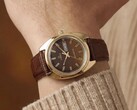 Kahverengi fumé kadranı ve altın tonlu kasasıyla Timex Q 1978 Day and Date, kahverengi deri kayışla bir bilekte gösteriliyor.