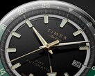 Timex Atelier GMT Première M1a’nın altın tonlu akrep ve yelkovanını, ışıldayan saat imlerini, tarih penceresini ve siyah-yeşil 24 saatlik GMT halkasını gösteren siyah kadranının yakın plan görüntüsü.