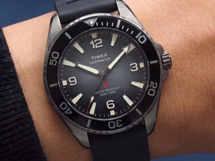 Dumanlı degrade kadranı, siyah seramik çerçevesi, ışıklı saat işaretleri ve siyah kauçuk kayışı bulunan Timex Deepwater Arctic 200 dalış saati, bilekte görülüyor.