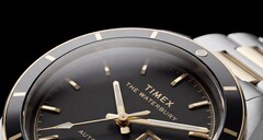 Siyah kadranlı Timex Waterbury Heritage Automatic saatin, kesikli ışıklı ibrelerini, saat işaretlerini, gün-tarih göstergesini ve siyah çerçevesini gösteren yakın çekim görüntüsü.