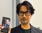 Hideo Kojima telefonunda bir Physint posteri gösteriyor