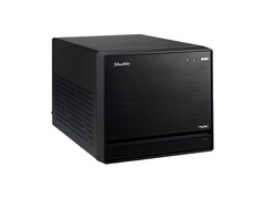 Görsel, minimal bir tasarıma sahip siyah bir küp gibi görünen Shuttle XPC Mini PC'nin kafa üstü görünümünü gösteriyor. 