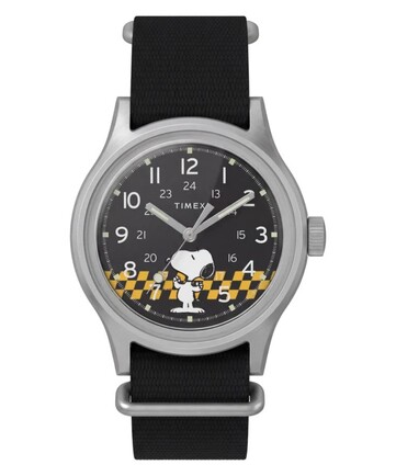 Peanuts x Timex MK1 modelinin önden görünümü; siyah kadranı, Arap rakamları, ışıklı ibreleri ve işaretleri ile kareli Snoopy grafiği görülüyor.