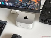 Monitör, klavye, fare ve hoparlör ile donatılmış bir oyun kurulumunda, masanın üzerinde duran Apple M6 Mac mini.