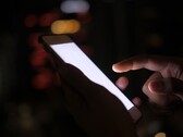 Karanlıkta parlayan ekranlı bir akıllı telefonu tutan el