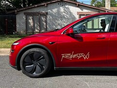 Bir Model Y üzerindeki Tesla Robotaxi yolculuk-paylaşım platformu logosu.