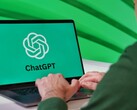 Bir adam, ekranında ChatGPT logosu görünen bir dizüstü bilgisayarda yazı yazıyor.