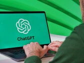 Bir adam, ekranında ChatGPT logosu görünen bir dizüstü bilgisayarda yazı yazıyor.