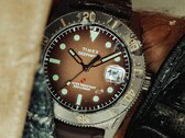 Huckberry x Timex Deepwater Reef 200 dalış saati; kahverengi kadranlı, paslanmaz çelik kasalı, siyah çerçeveli ve uyumlu kahverengi kayışlı.
