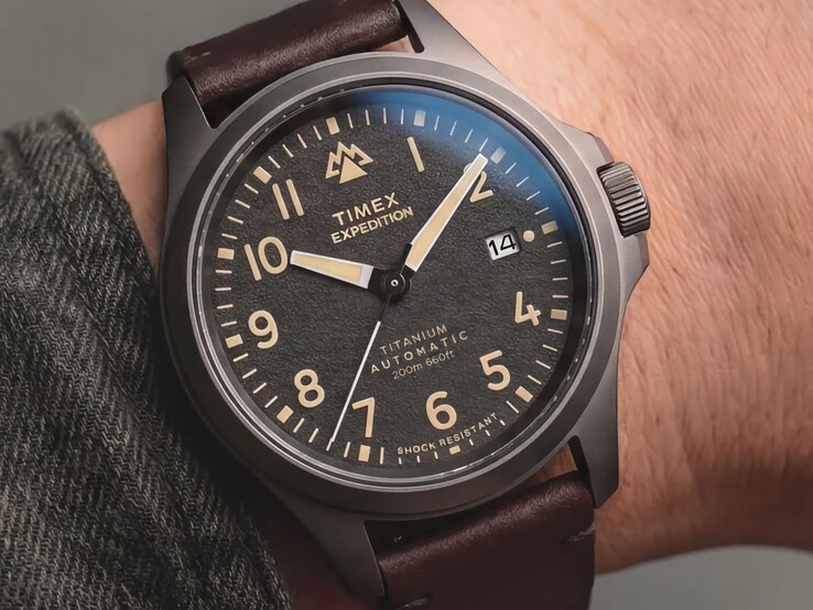 Timex Expedition Field Post Titanium saat, bir kişinin bileğinde takılı olarak gösterilmiştir; saatin siyah kadranı ve siyah titanyum kasası görülmektedir.