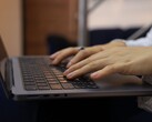 Karanlık bir dizüstü bilgisayarın klavyesinde yazan eller