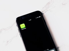 Beyaz bir masanın üzerinde WhatsApp uygulamasını gösteren bir akıllı telefon