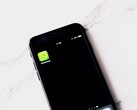 Beyaz bir masanın üzerinde WhatsApp uygulamasını gösteren bir akıllı telefon