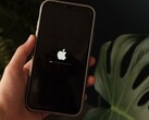 Bir el bir iPhone tutuyor; ekranda Apple logosu ve bir ilerleme çubuğu yanıyor.