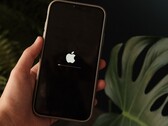 Bir el bir iPhone tutuyor; ekranda Apple logosu ve bir ilerleme çubuğu yanıyor.
