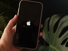 Bir el bir iPhone tutuyor; ekranda Apple logosu ve bir ilerleme çubuğu yanıyor.