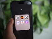 Bir el, Gemini, ChatGPT ve Claude gibi uygulamaların bulunduğu AI adlı bir klasörü gösteren bir akıllı telefonu tutuyor.